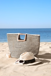 Stylish beach accessories on sand near sea