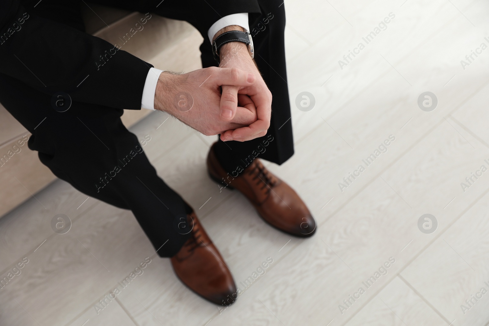 Photo of Groom wearing elegant wedding shoes indoors, closeup