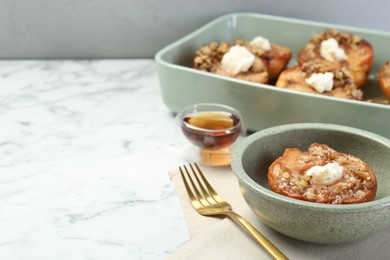 Photo of Tasty baked quinces with nuts and cream cheese on white marble table. Space for text