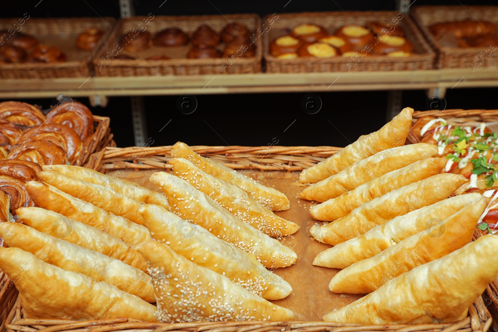 Photo of Tray with fresh puff pastry turnovers on bakery showcase