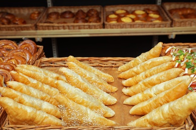 Photo of Tray with fresh puff pastry turnovers on bakery showcase