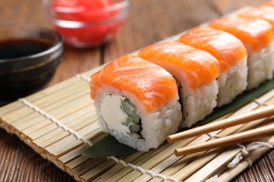 Photo of Tasty sushi rolls served on wooden table, closeup