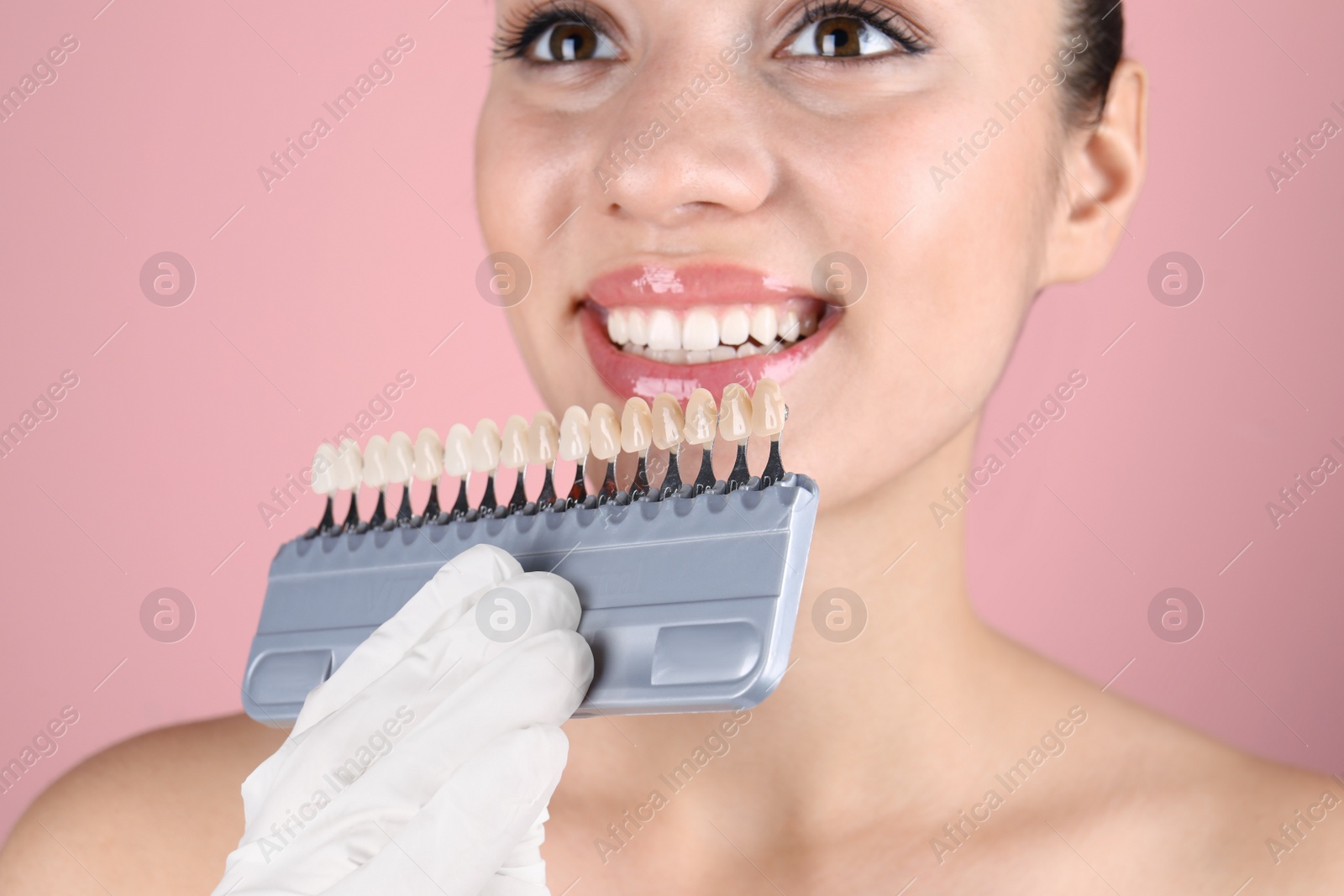 Photo of Dentist checking young woman's teeth color, closeup