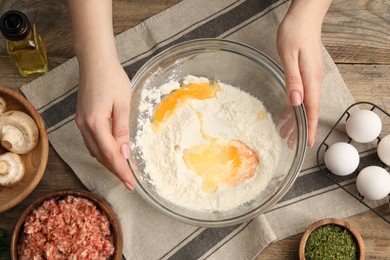 Photo of Woman making dough at wooden table, closeup