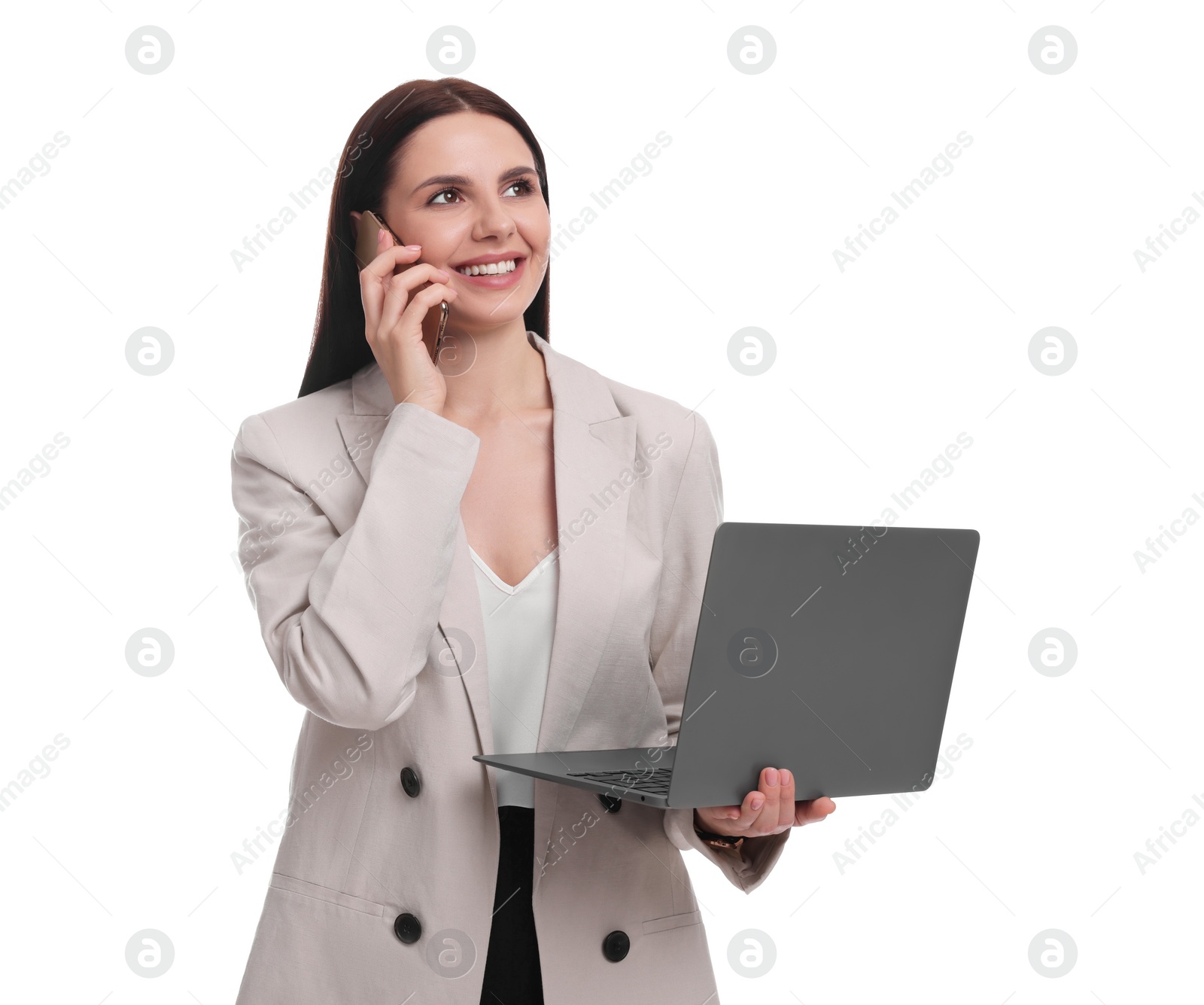 Photo of Beautiful businesswoman in suit with laptop talking on smartphone against white background