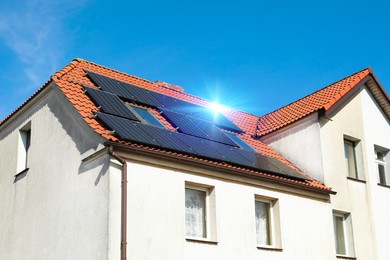 Photo of House with installed solar panels on roof. Alternative energy