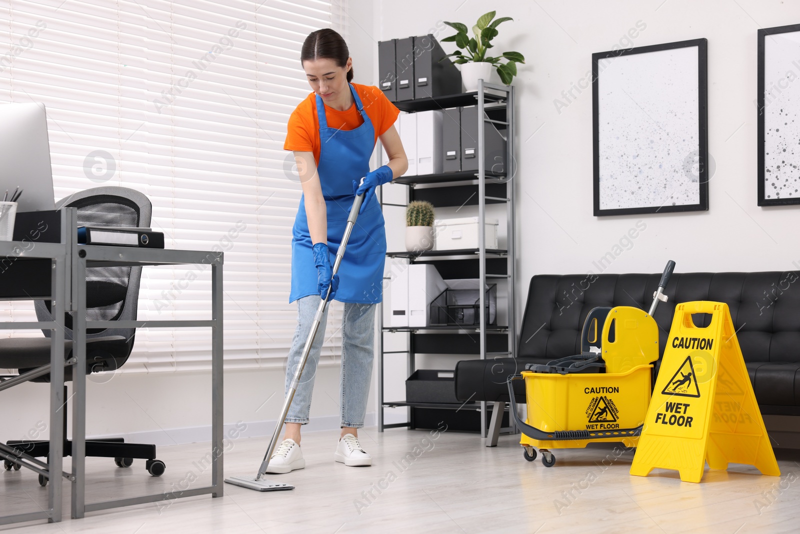 Photo of Cleaning service. Woman washing floor with mop in office