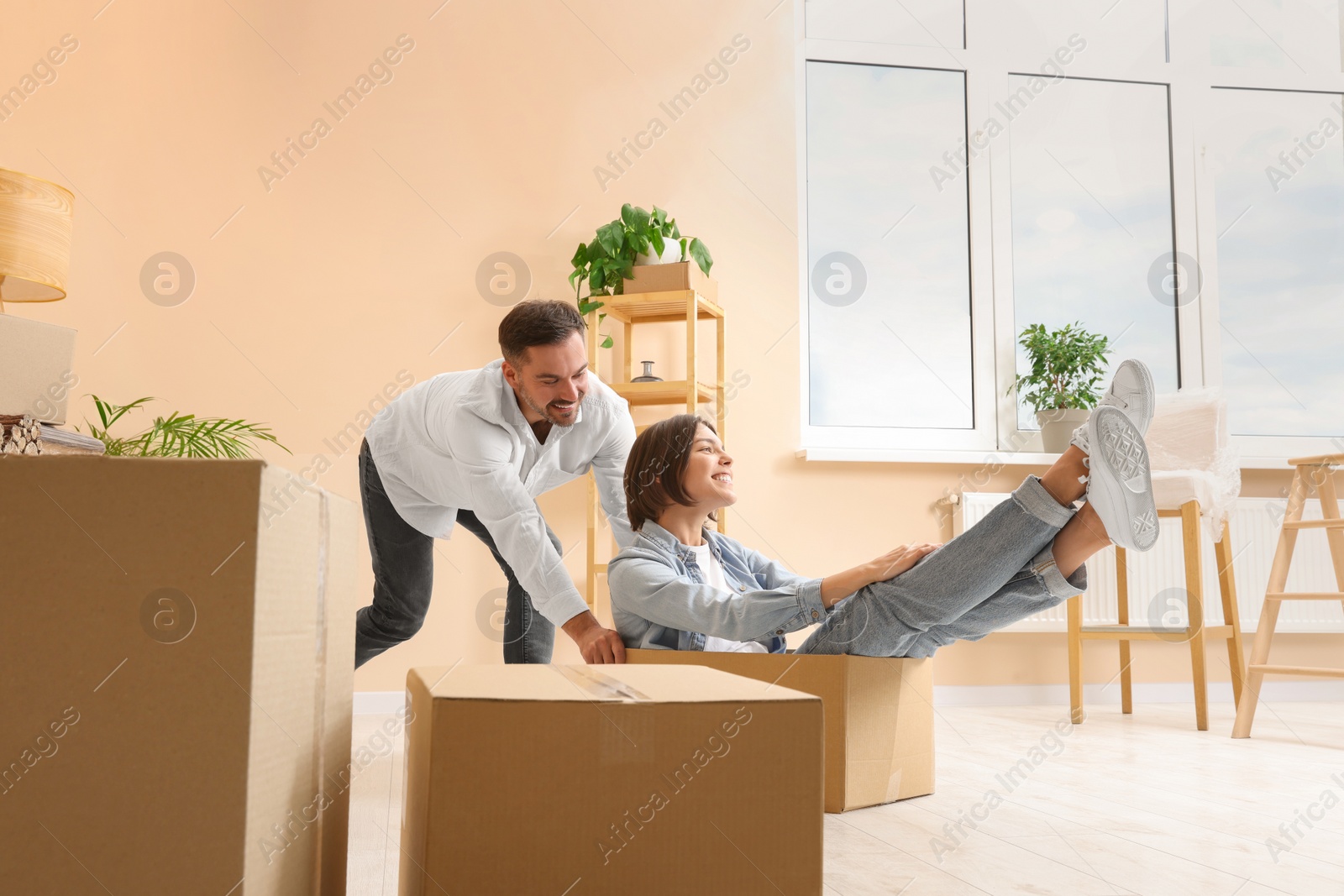 Photo of Happy couple having fun in new apartment. Moving day