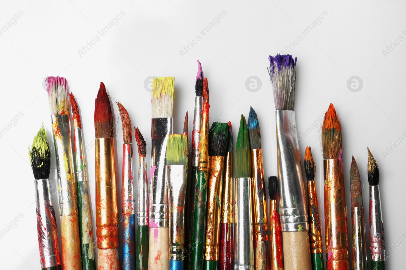 Photo of Different paint brushes on white background, top view