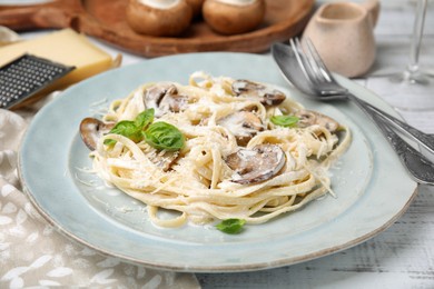 Photo of Delicious pasta with mushrooms and cheese on white wooden table, closeup
