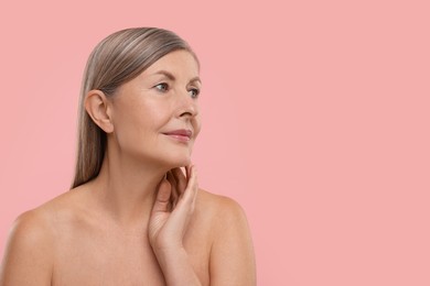 Photo of Beautiful woman touching her neck on pink background, space for text