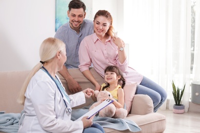 Family doctor visiting ill child at home