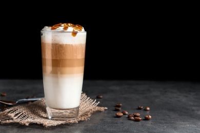 Glass with delicious caramel frappe on table