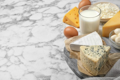 Different dairy products on marble table. Space for text