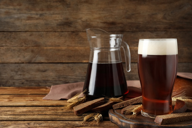 Photo of Composition with delicious kvass, spikes and bread on wooden table