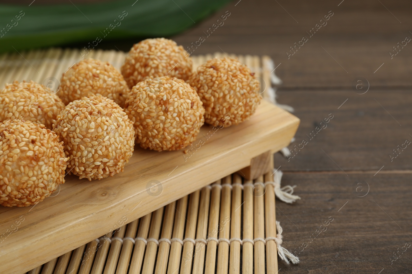 Photo of Many delicious sesame balls on wooden table, closeup. Space for text