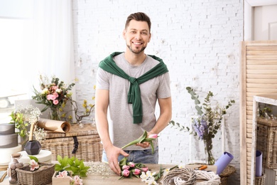 Male decorator creating beautiful bouquet at table