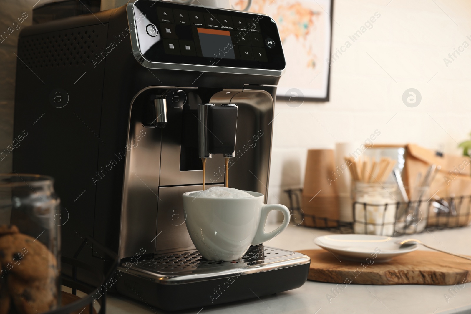 Photo of Modern coffee machine making cappuccino in office kitchen, space for text