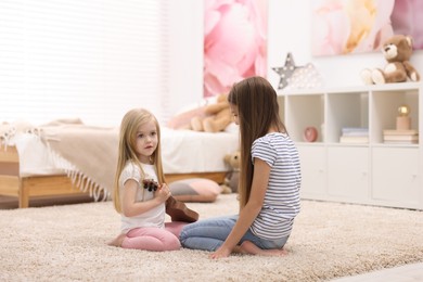 Cute little sisters spending time together at home