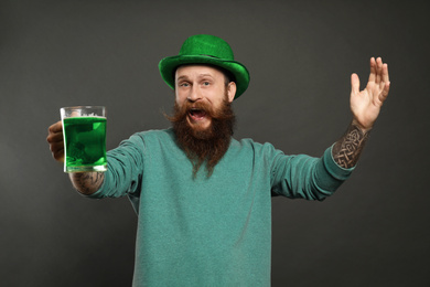 Bearded man with green beer on grey background. St. Patrick's Day celebration