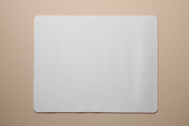 Photo of One mouse pad on beige background, top view. Space for text