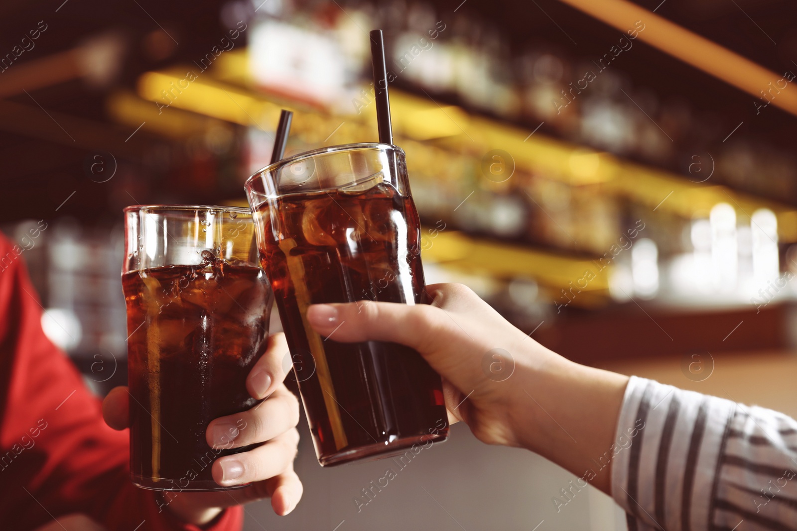 Photo of Young couple with glasses of refreshing cola indoors, closeup