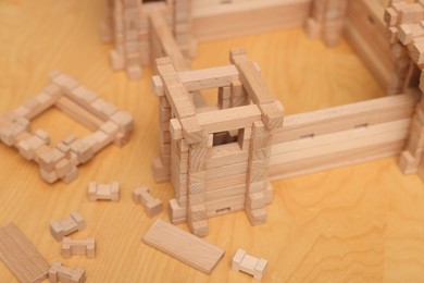 Photo of Wooden fortress and building blocks on table. Children's toy