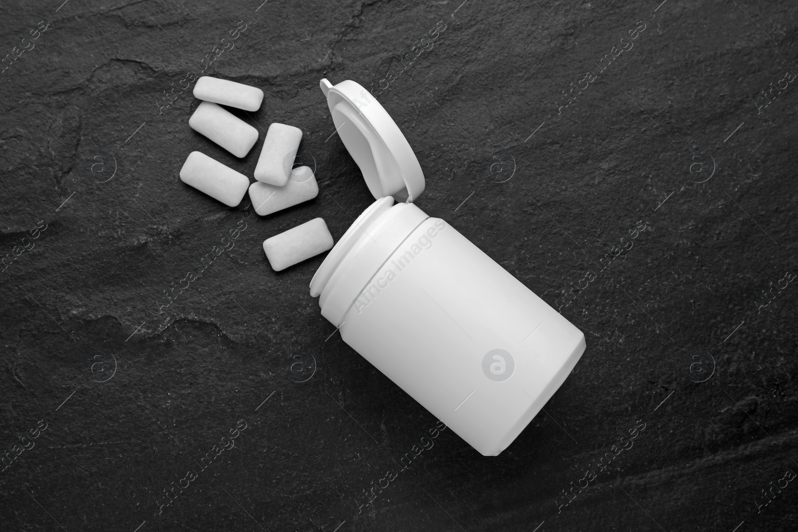 Photo of Jar with chewing gums on black table, flat lay