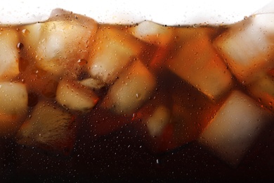 Photo of Closeup view of tasty refreshing cola with ice cubes