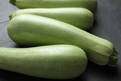 Raw green zucchinis on black slate table, closeup