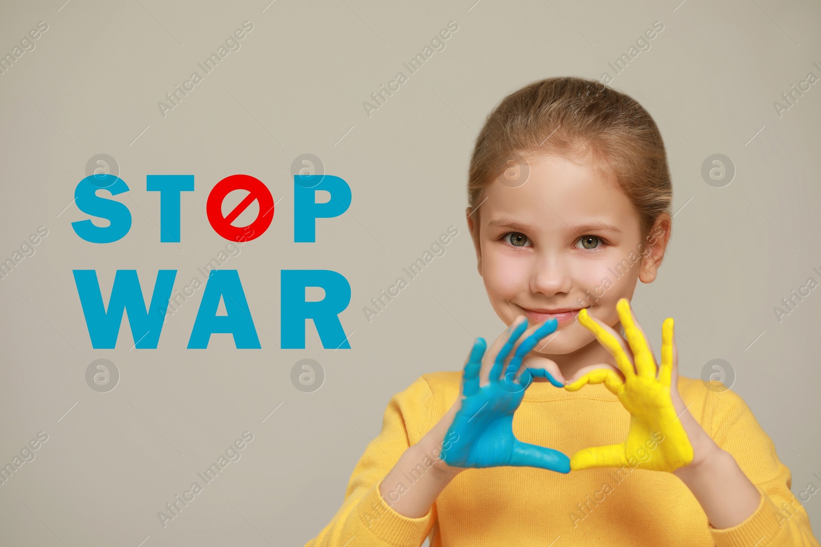 Image of Stop war. Little girl making heart with her hands painted in colors of Ukrainian flag on light background