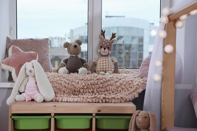 Photo of Stylish child room with storage for toys near window