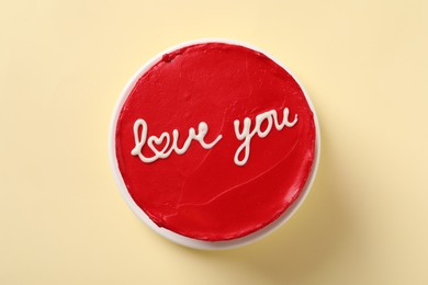 Photo of Bento cake with text Love You on beige table, top view. St. Valentine's day surprise