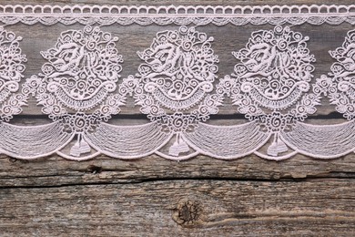 Photo of Beautiful lace on wooden table, top view. Space for text