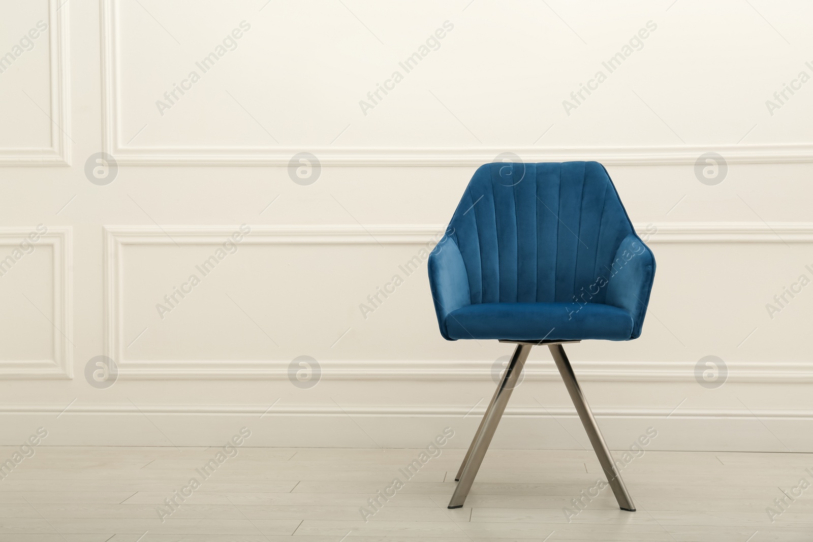 Photo of Modern blue armchair near white wall indoors. Space for text