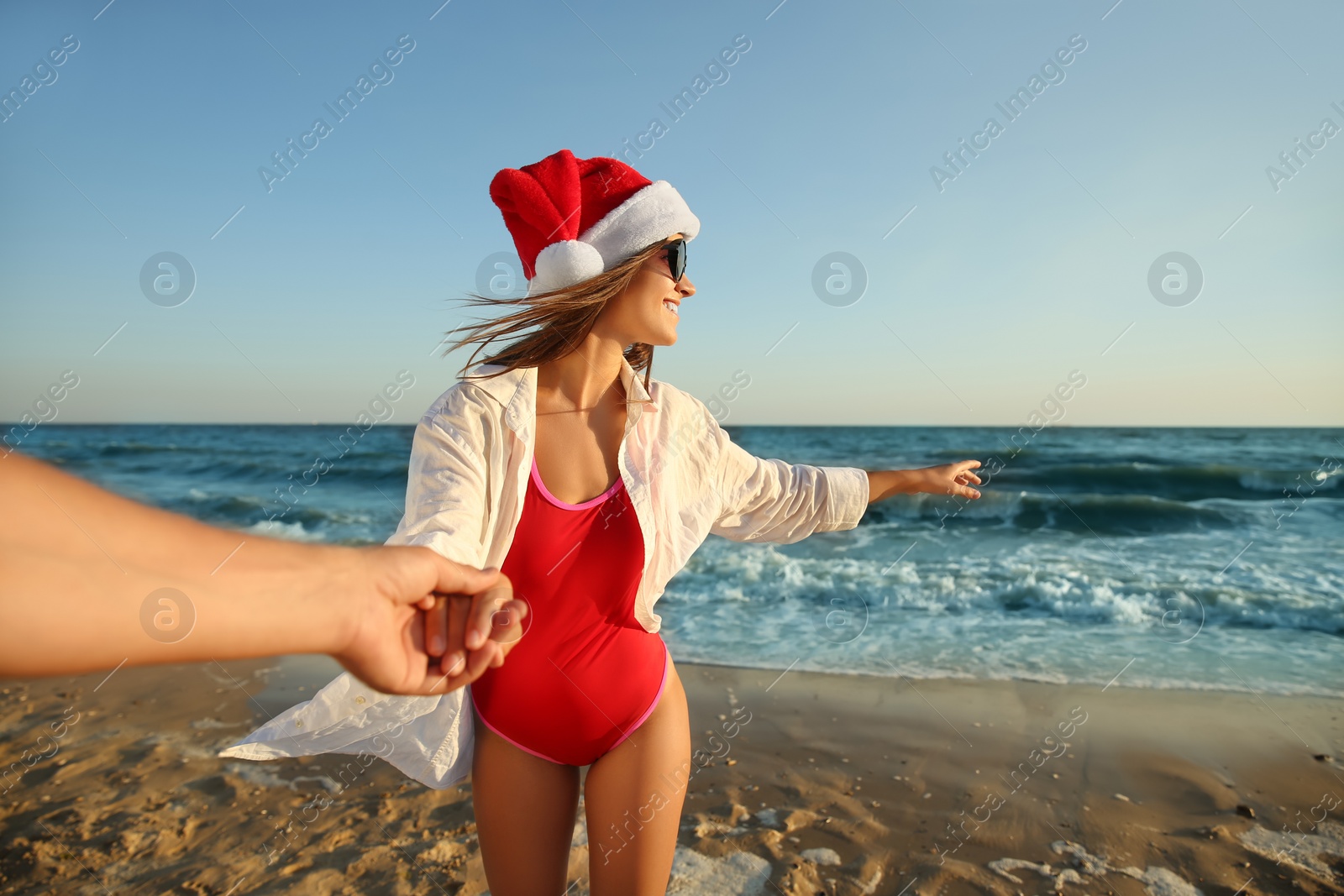 Photo of Lovely couple with Santa hat on beach. Christmas vacation