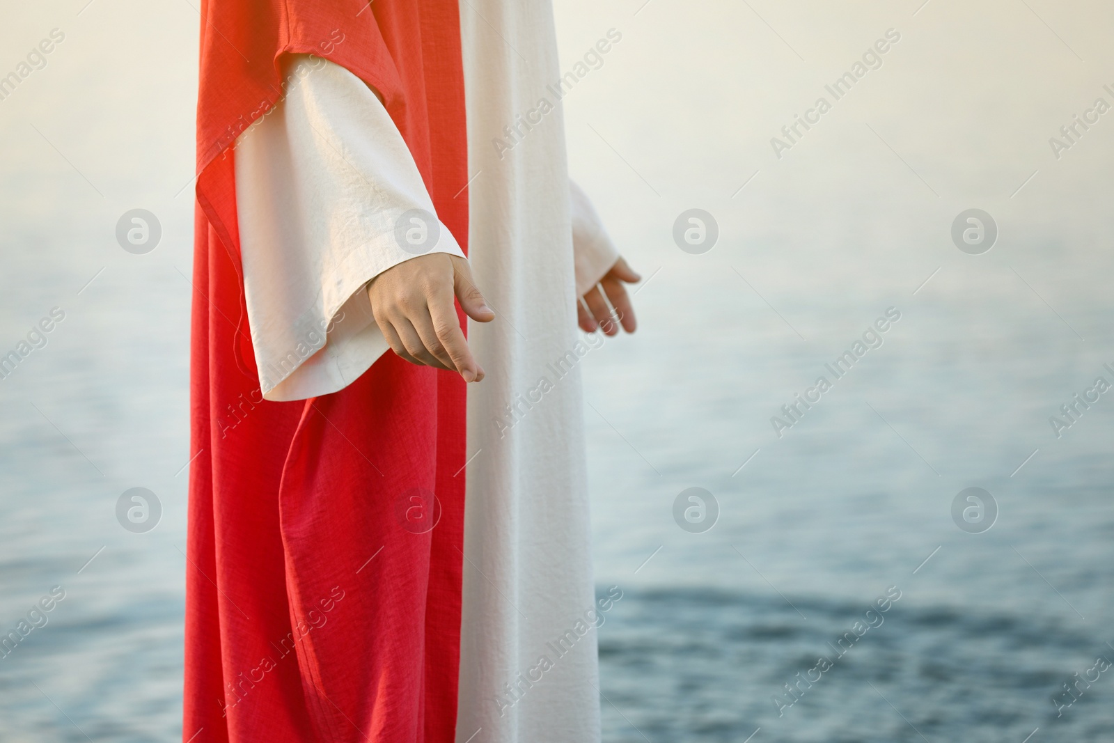 Photo of Jesus Christ near water outdoors, closeup. Space for text