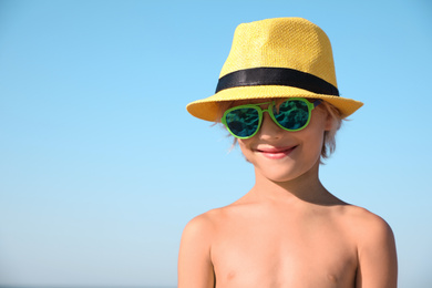 Cute little child wearing beach hat on sunny day, space for text