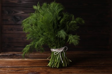 Photo of Bunch of fresh green dill on wooden table