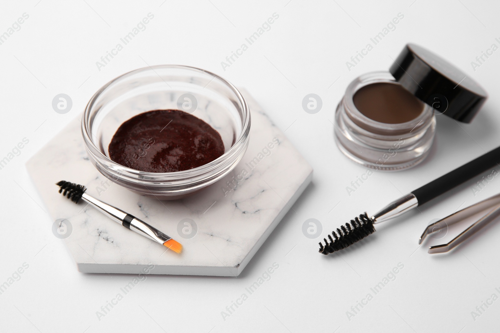 Photo of Eyebrow henna and professional tools on white background, closeup