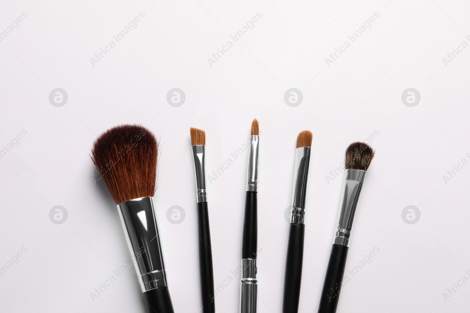 Photo of Set of makeup brushes on white background, flat lay. Space for text