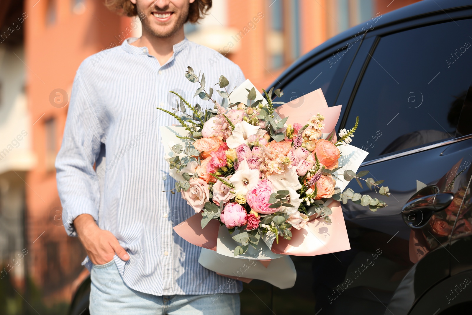 Photo of Man with beautiful flower bouquet near car on street, closeup