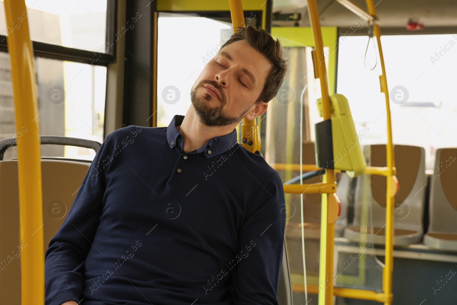 Photo of Tired man sleeping while sitting in public transport