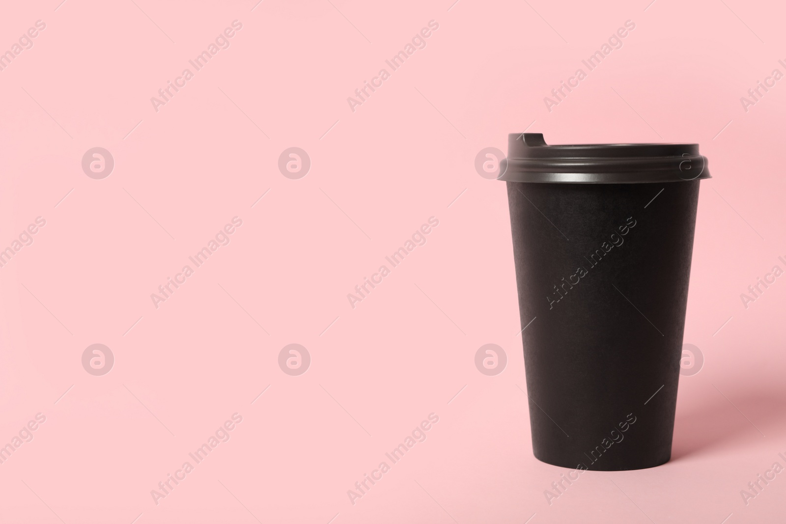 Photo of Takeaway paper coffee cup on pink background. Space for text