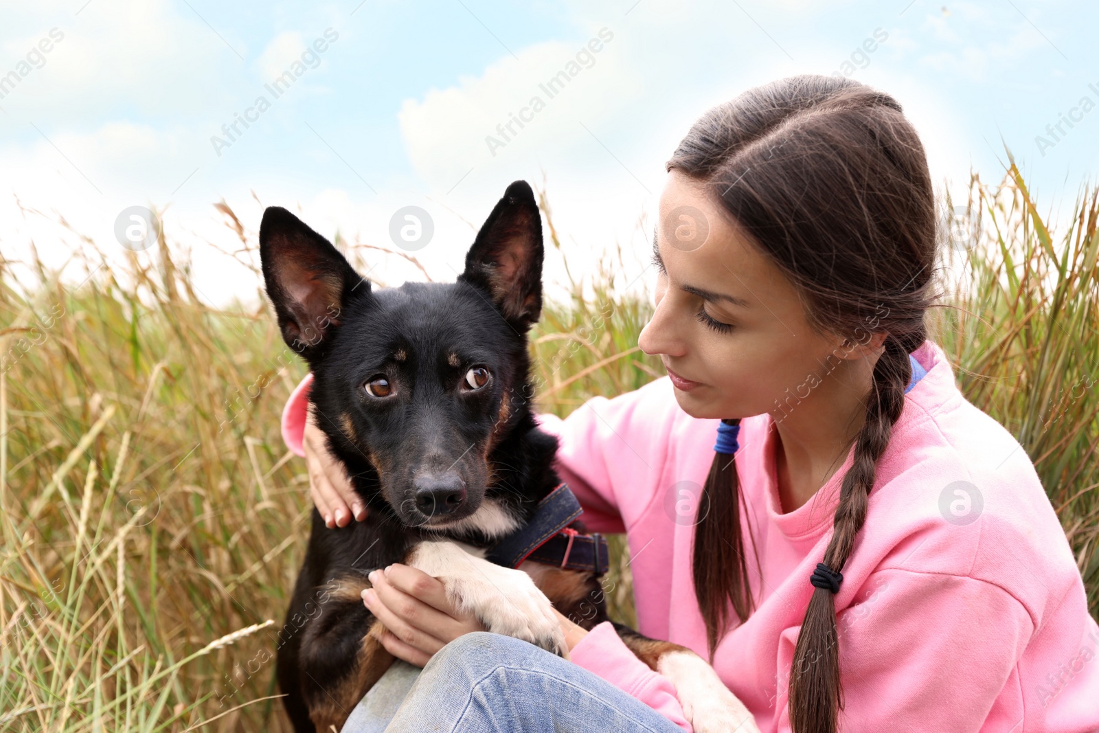 Photo of Female volunteer with homeless dog at animal shelter outdoors