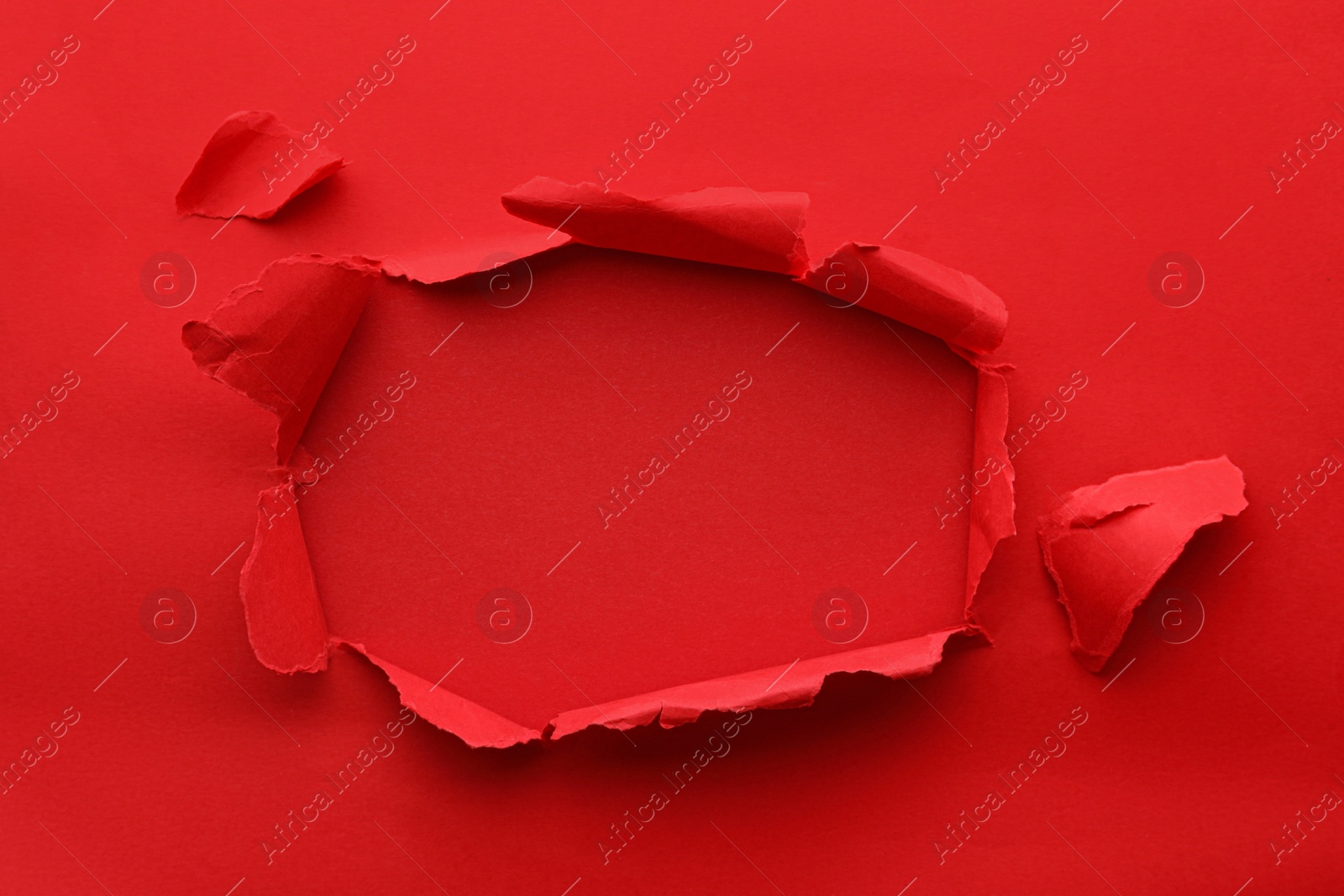 Photo of Hole in red paper on color background