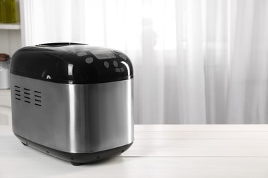 Modern breadmaker on white wooden table indoors, space for text