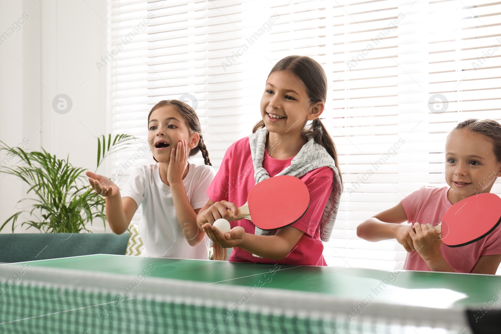 Photo of Cute happy children playing ping pong indoors