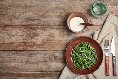 Tasty green beans with sesame seeds served for dinner on wooden table, top view