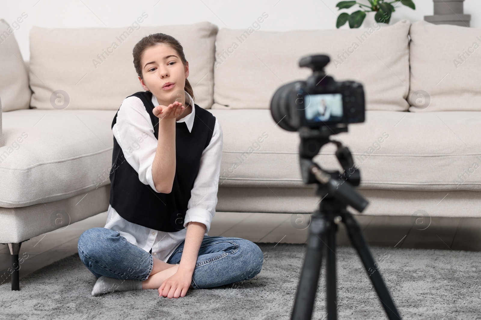 Photo of Teenage blogger sending air kiss to her subscribers while streaming at home